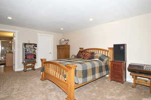 Bedroom with light colored carpet and recessed lighting