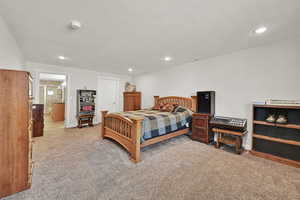 Carpeted bedroom with recessed lighting and ensuite bath