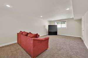 Living area with light colored carpet and recessed lighting