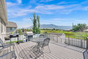 Wooden terrace featuring a mountain view and grilling area