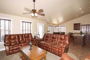Living area with a ceiling fan, vaulted ceiling, a chandelier, and recessed lighting