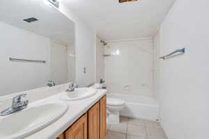 Bathroom with double vanity, bathtub / shower combination, and tile patterned floors