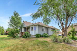 View of side of home featuring a lawn and stucco siding