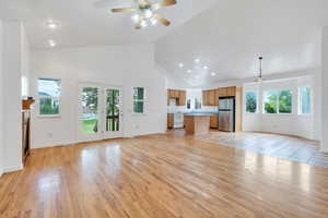 Unfurnished living room with high vaulted ceiling, a ceiling fan, light wood-style flooring, recessed lighting, and a fireplace