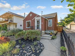 View of front of home with brick siding and roof with shingles