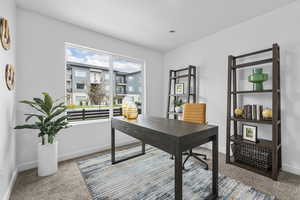 Home office featuring carpet and baseboards