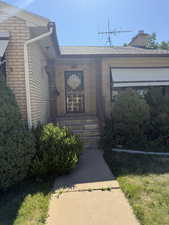 Entrance to property with brick siding and a chimney