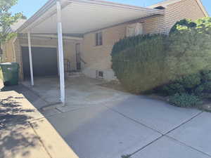 View of home's exterior with concrete driveway, an attached carport, and brick siding