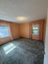 Carpeted empty room with a textured ceiling