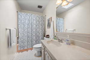Full bath featuring a skylight, vanity, tile patterned floors, and shower / bath combo with shower curtain
