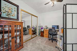 Office area featuring carpet, ceiling fan, and a textured ceiling