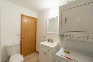 Bathroom featuring stacked washer and clothes dryer and vanity