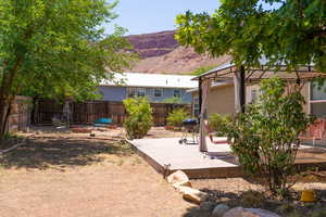 Fenced backyard featuring a fire pit, a gazebo, a mountain view, and a patio