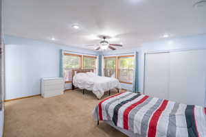 Carpeted bedroom with recessed lighting and ceiling fan