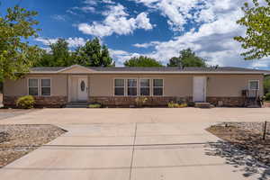 Manufactured / mobile home featuring stone siding, driveway, and entry steps