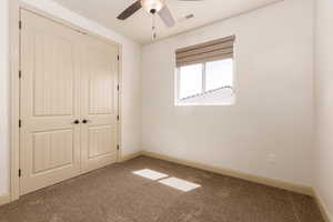 Unfurnished bedroom with carpet flooring, a closet, and ceiling fan
