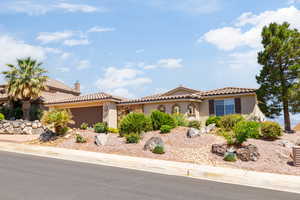 Mediterranean / spanish-style house featuring stucco siding, an attached garage, a tile roof, and driveway