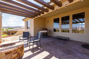 View of patio / terrace with an outdoor fire pit, a mountain view, a grill, and a pergola
