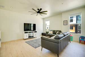 Living room featuring a ceiling fan and light wood-type flooring