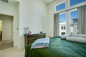 Bedroom with light wood-style floors and a high ceiling