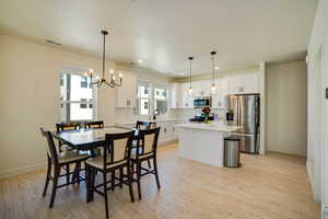 Dining space with a chandelier, light wood-type flooring, and recessed lighting