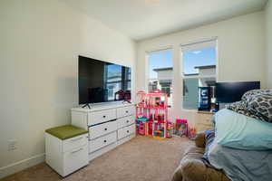 Bedroom with light carpet and baseboards