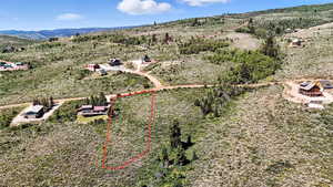 Aerial view of property and surrounding area featuring property parcel outlined and mountains