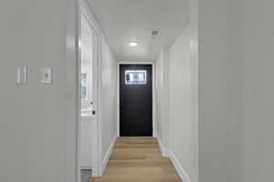 Doorway featuring light wood-style floors and baseboards