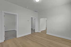 Unfurnished room featuring light wood-style flooring and a smoke detector