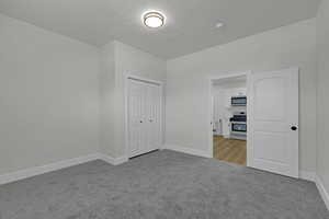 Unfurnished bedroom with carpet flooring, a textured ceiling, and a closet