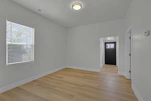 Spare room featuring light wood-type flooring and baseboards