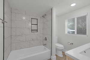 Full bathroom with vanity, shower / bath combination, and a textured ceiling