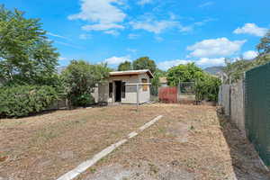 Fenced backyard with an outdoor structure