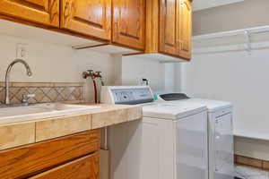 Washroom featuring cabinet space and washer and clothes dryer