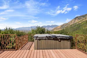Wooden terrace with a hot tub and a mountain view