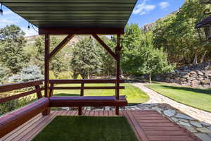 Wooden terrace featuring a lawn