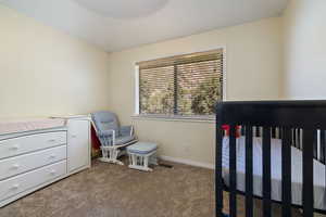 Bedroom with carpet flooring and a crib