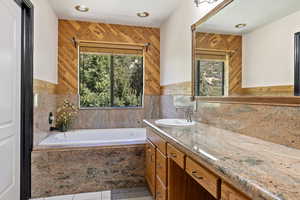 Full bathroom with vanity, a bath, wood walls, tile patterned floors, and tasteful backsplash