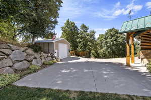 View of patio with an outdoor structure and a garage