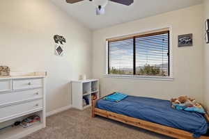Bedroom with light colored carpet, vaulted ceiling, and a ceiling fan