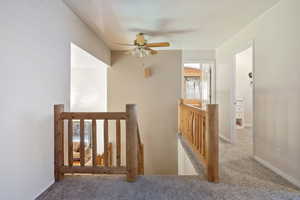 Corridor with an upstairs landing and carpet flooring