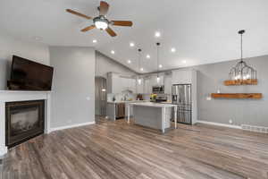 Kitchen with open floor plan, appliances with stainless steel finishes, a ceiling fan, light countertops, and recessed lighting