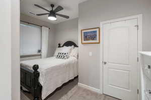 Carpeted bedroom with baseboards and a ceiling fan