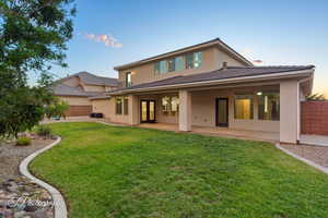Back of house with stucco siding, french doors, a patio area, and a tiled roof