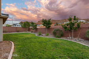 Yard at dusk featuring a fenced backyard