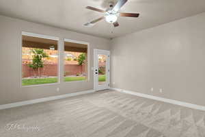 Spare room featuring light carpet and a ceiling fan