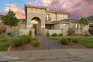View of front of property featuring stone siding, stucco siding, and a fenced front yard