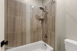 Bathroom featuring toilet and shower / tub combination