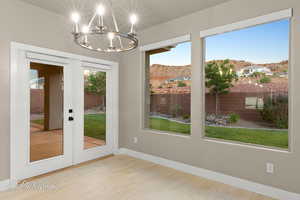 Doorway to outside featuring french doors, a chandelier, a mountain view, and wood finished floors