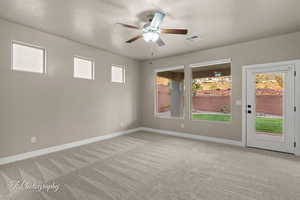 Spare room featuring a ceiling fan and light carpet